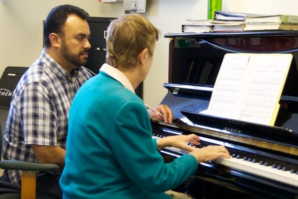 Dos adultos tocando el piano juntos: la música ayuda al cerebro de los adultos